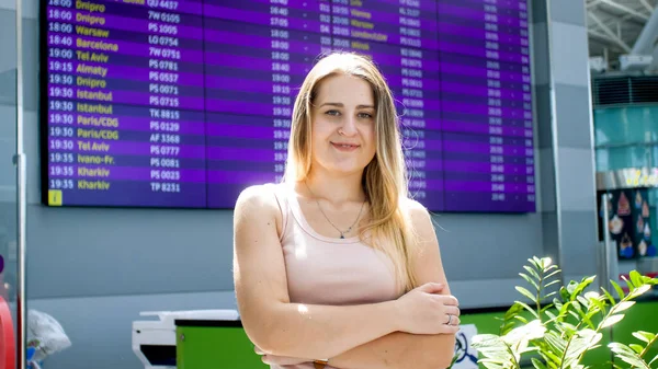 Portrét usmívající se mladé ženy v moderním letištním terminálu při pohledu do kamery — Stock fotografie