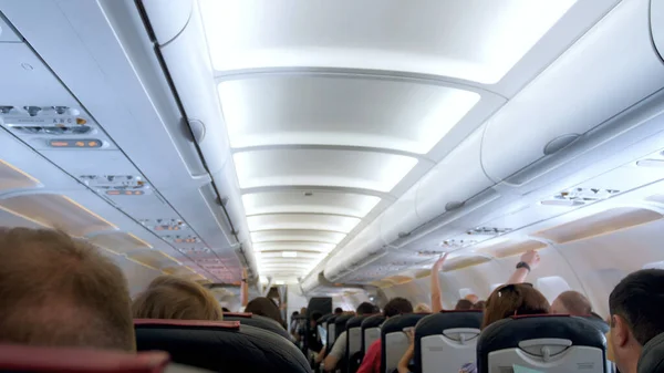 Размытое изображение длинного ряда сидений и потолка в самолете — стоковое фото