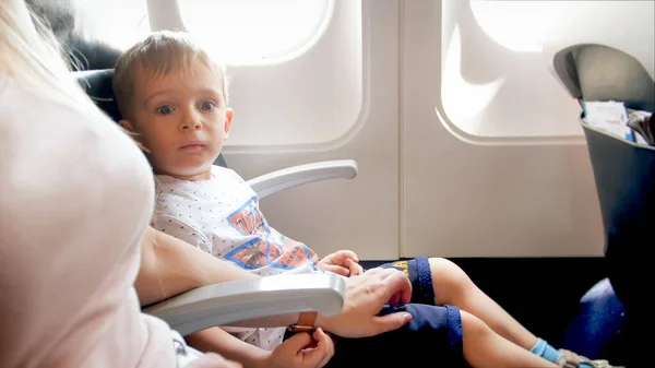 Joven madre calma a su pequeño hijo antes del primer vuelo en avión — Foto de Stock