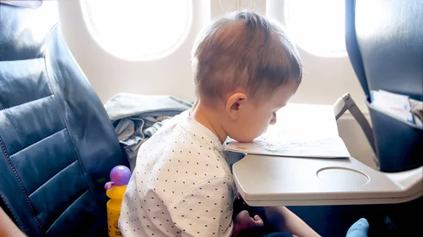 Porträt eines gelangweilten kleinen Jungen während eines langen Fluges im Flugzeug — Stockfoto