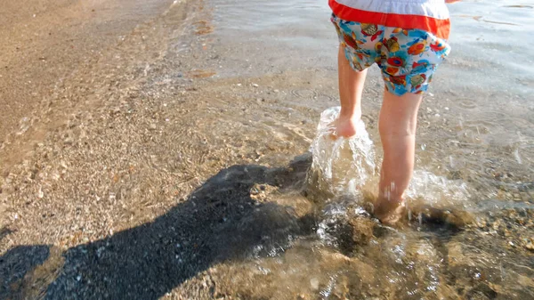 Imagem de close-up de crianças pés correndo na água do mar na praia — Fotografia de Stock