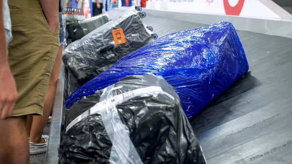 Closeup image of wrapped suitcases lying on the luggage claim line at airport — Stock Photo, Image