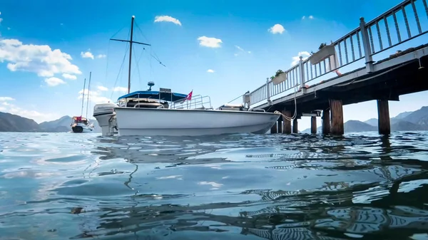 Vista desde el nivel del agua en yates y barcos amarrados en muelle de madera en el mar —  Fotos de Stock