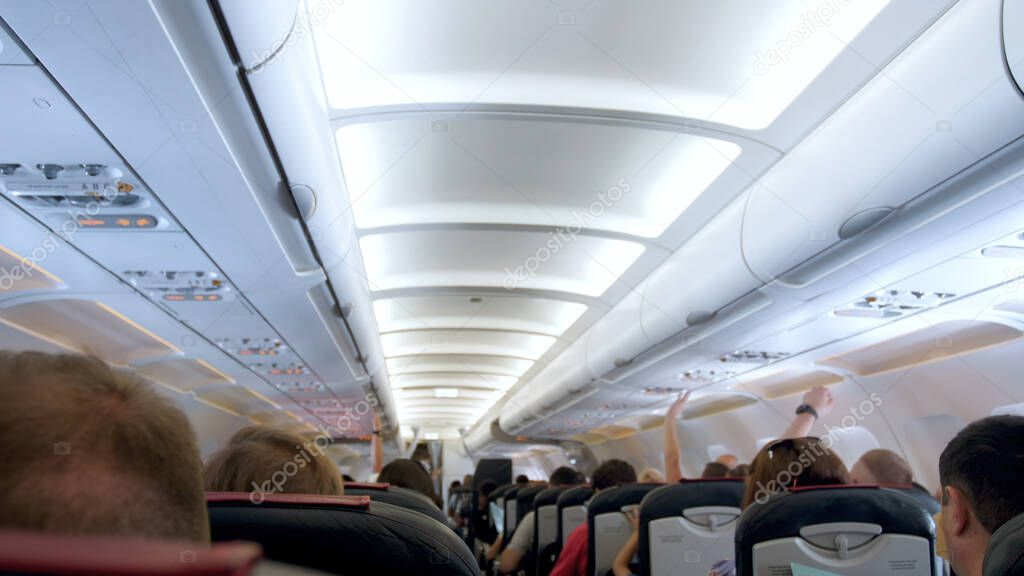 Blurred image of long row of seat and ceiling in airplane