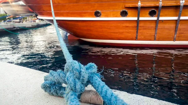 Closeup image of old wooden ship moored in sea port with blue rope — Stock Photo, Image