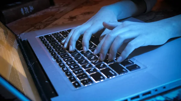 Closeup image of girls hands typing on laptop keyboard at night — Stock Photo, Image