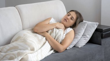 Kanepenin altında kendini kötü hisseden hasta bir kadının portresi.