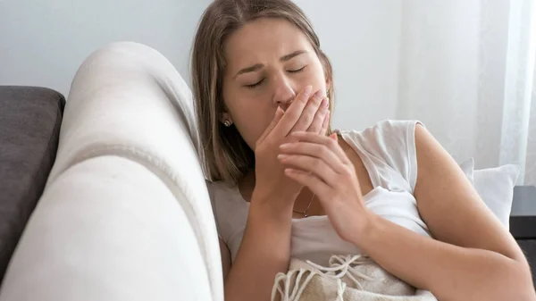 Porträtt av sjuk kvinna med virus liggande på soffan och hosta — Stockfoto