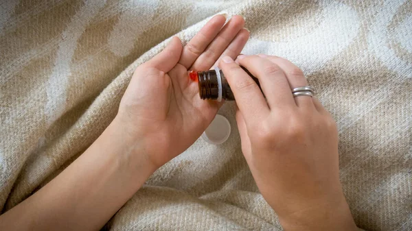 Imagen de primer plano de la mujer vertiendo píldoras o tabletas en la mano de la botella de vidrio —  Fotos de Stock