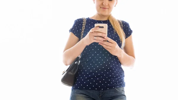 Изолированное изображение молодой женщины с сумкой, печатающей сообщение на смартфоне — стоковое фото