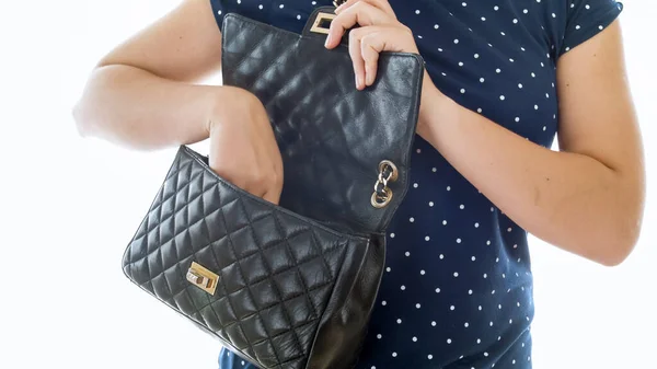 Femme ouvrant son sac à main en cuir noir et sortant des choses — Photo