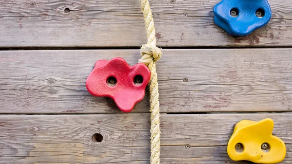 Dinding kayu untuk memanjat dengan pegangan plastik dan tali di tempat bermain — Stok Foto