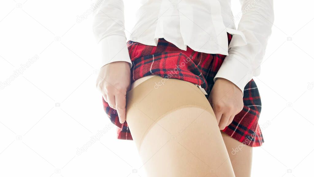 Sexy girl in school uniform adjusting nylon stockings and garter belt