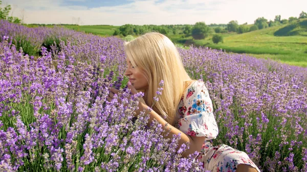 Портрет улыбающейся молодой женщины, пахнущей цветами на лавандовом поле в Провансе — стоковое фото