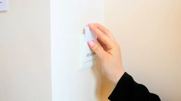 Mão feminina inserindo cartão chave eletrônico no interruptor elétrico do quarto de hotel — Fotografia de Stock