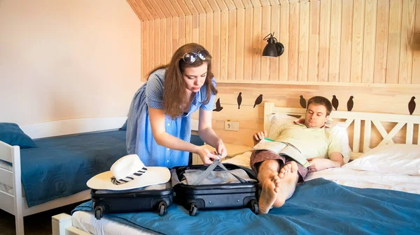 Ung fru packa upp resväska efter ankomsten till hotellrummet — Stockfoto