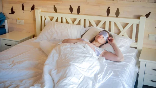 Porträtt av vacker sovande kvinna liggande i pärla bär mask för ögon — Stockfoto