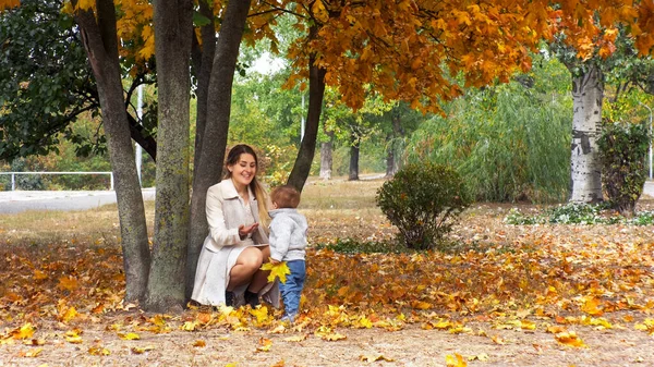 Beautfiul jeune femme avec petit fils dans le parc d'automne — Photo