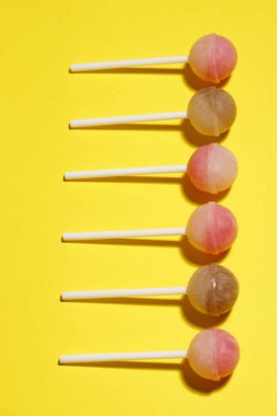 Sarı bir arka plan üzerinde topu lolipop.