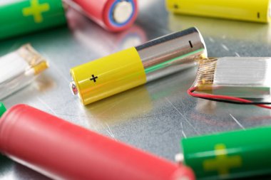 Metal bir masada bir sürü pil var..