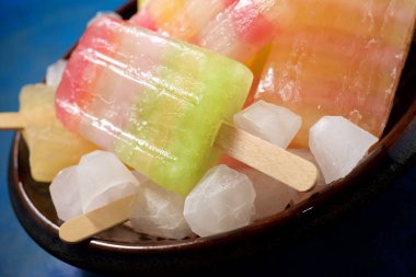 Mavi bir tabloda Popsicles.