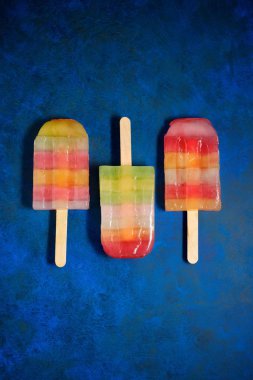 Mavi bir tabloda Popsicles.