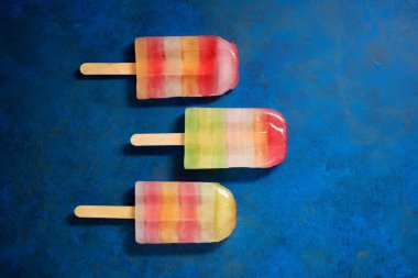 Mavi bir tabloda Popsicles.