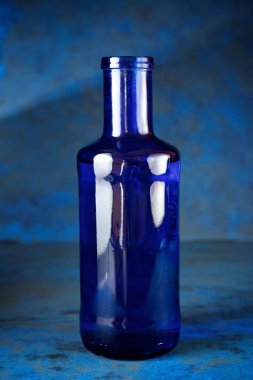 Masadaki mavi cam şişe.