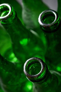 Metal bir masada yeşil bira şişeleri