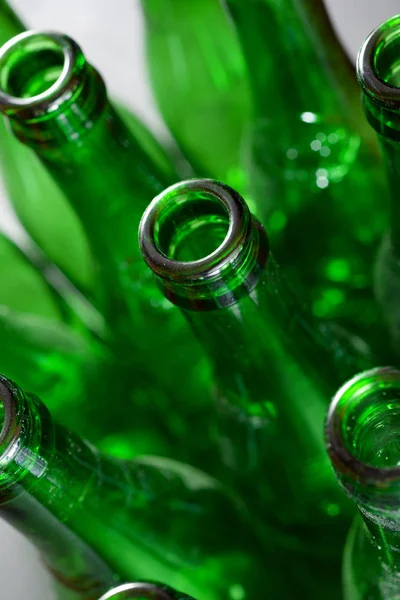 Metal bir masada yeşil bira şişeleri