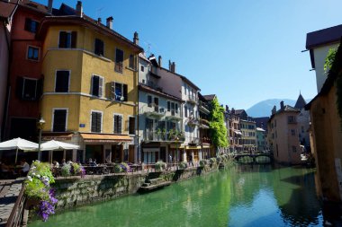 Annecy, Fransa - 12 Ağustos 2013: Güneşli bir sabahın tadını çıkaran turistler. Kanallar arasında Lisle Sarayı olarak bilinen ortaçağ kalesi göze çarpar..