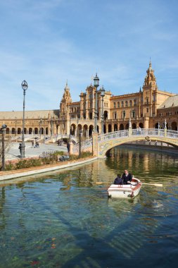 Seville, İspanya - 5 Ocak 2014: Parque Maria Luisa 'da bulunan İspanya Meydanı' nda yürüyen turistler.