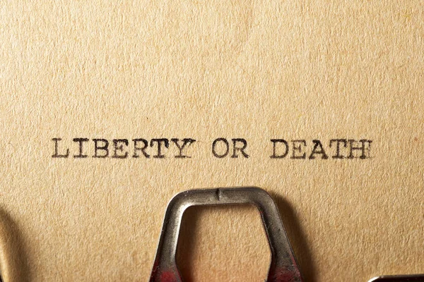 Liberty or death text written on a paper.