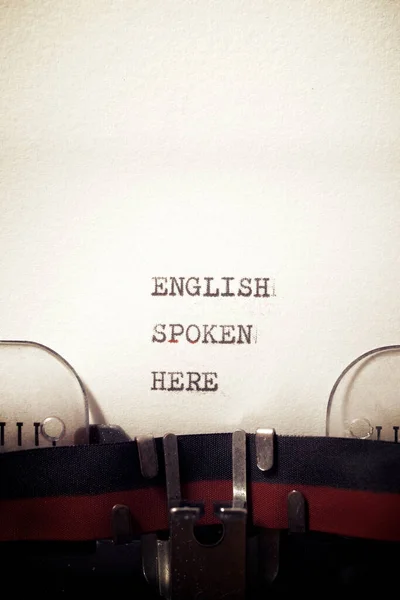 English spoken here phrase written with a typewriter.
