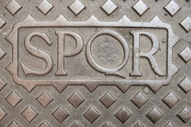 SPQR, Senatus Populusque Romanus 'un kısaltması, Roma, İtalya' daki dökme demir rögar kapağında.