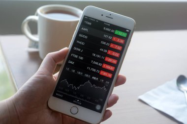 Taipei Airport, Tayvan - 10 Mayıs 2015: Apple iphone Apple hisse senedi fiyatı evrim onun büyük ekranda en son Apple Inc satış denize indirmek sırasında görüntüleme tutan el.