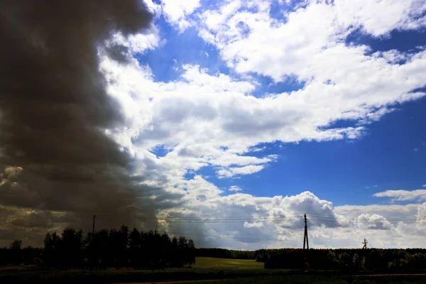 In de buurt van het dorp. Storm. De hemel voldoet aan een onweersbui. De zon schijnt door de wolken — Stockfoto