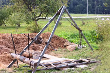 su sütunu kazma için zemin yetiştirmek için metal paslı retro el vinç. Bulutlu bir günde fotoğraf çekildi.