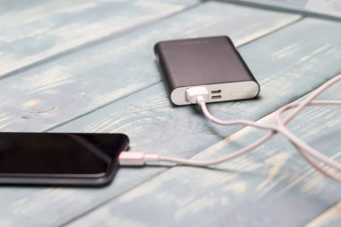 cep telefonu ve bir ahşap antika arka plan üzerinde şarj etmek için yedek pil.