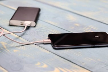 cep telefonu ve bir ahşap antika arka plan üzerinde şarj etmek için yedek pil.