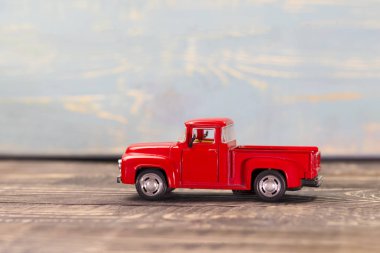 koyu ahşap arka plan üzerinde kırmızı kamyonet dayanacak insan eli.