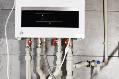 Isıtma sistemi plastik borular, vanalar ve diğer ekipmanlar kazan dairesi içinde.