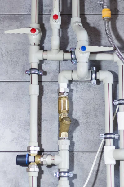 Heating system with plastic pipes, valves and other equipment in the boiler room.