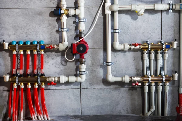 Heating system with plastic pipes, valves and other equipment in the boiler room.