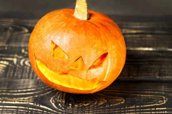 Halloween, two pieces or one, in the eye is a lantern camera with burning candles on a black background. Halloween celebration, celebration