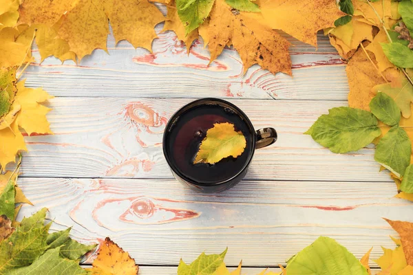 Tee Einer Dunklen Transparenten Tasse Mit Herbstblättern Auf Einem Blauen — Stockfoto