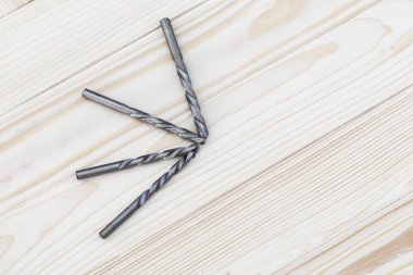 Metal matkap closeup ahşap arka plan üzerinde. yakın çekim. akçaağaç yaprakları, odak yok vardır.