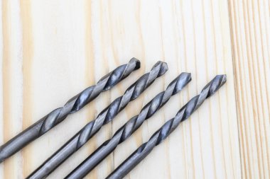 Metal matkap closeup ahşap arka plan üzerinde. yakın çekim. akçaağaç yaprakları, odak yok vardır.