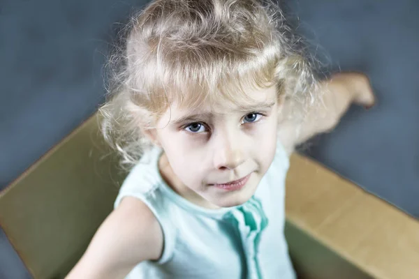 Little Blonde Smiles Cardboard Box Shows Hands Dark Background Toning — Stock Photo, Image