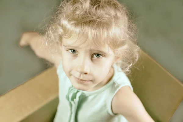 Little Blonde Smiles Cardboard Box Shows Hands Dark Background Toning — Stock Photo, Image